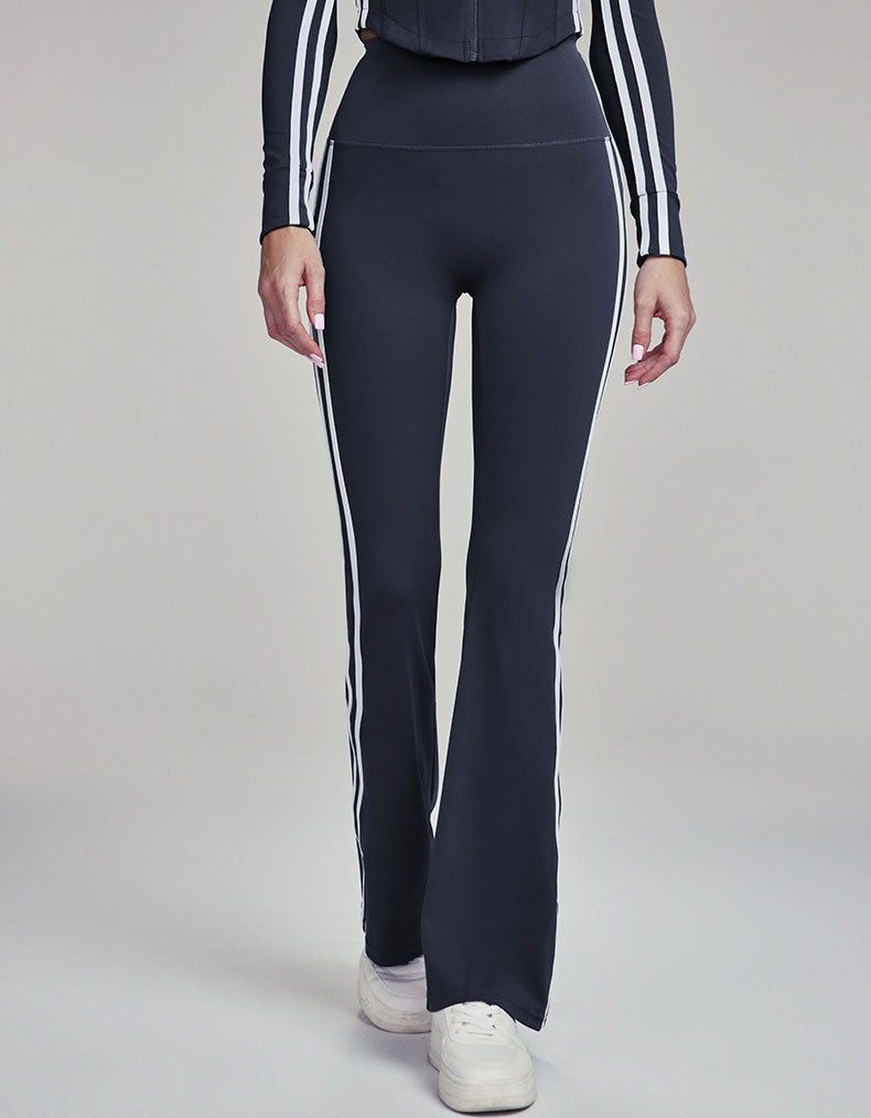 Navy leggings with white stripes worn by a person on a gray background
