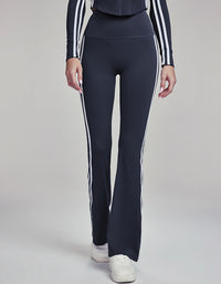 Navy leggings with white stripes worn by a person on a gray background