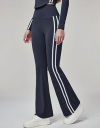 Navy blue pants with white stripes worn by a person on a gray background side view