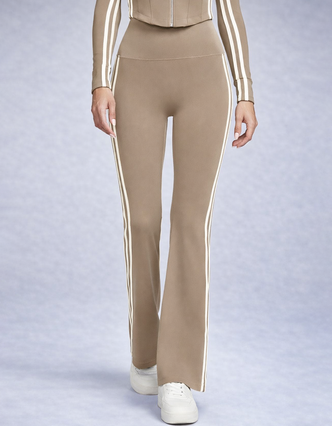 Beige pants with white stripes worn by a person on a light gray background