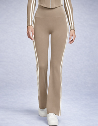 Beige pants with white stripes worn by a person on a light gray background