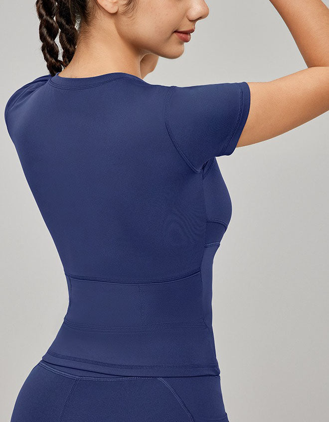 Navy blue athletic top worn by a person on a gray background back view