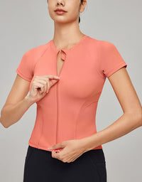 Woman wearing a coral short-sleeve top against a gray background