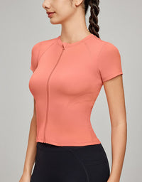 Woman wearing a coral athletic top against a gray background