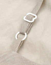 Close-up of beige fabric with a strap and white buckle.