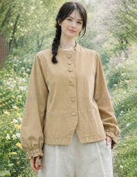 Woman wearing a beige jacket in a garden setting