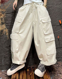 Beige cargo pants worn by a person against a dark textured wall.