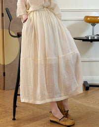 Person wearing a long beige skirt in an indoor setting