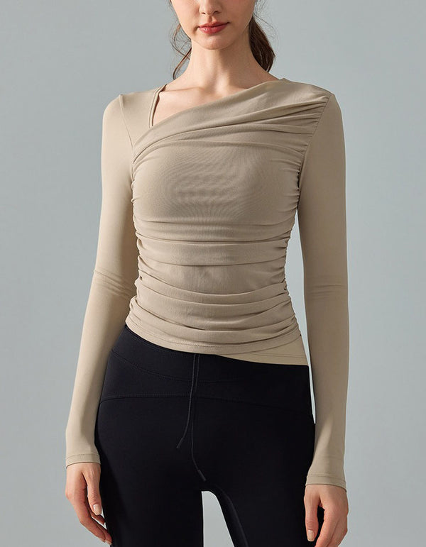 Beige long-sleeve top worn by a person on a gray background
