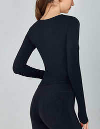 Black long-sleeve top worn by a person on a gray background