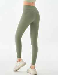 Person wearing olive green leggings on a white background
