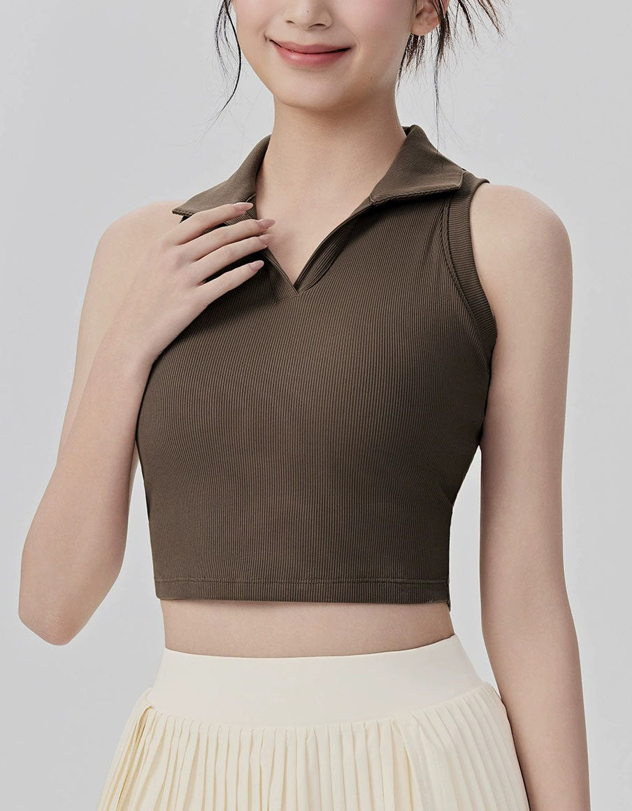 Woman wearing a brown sleeveless top against a plain background