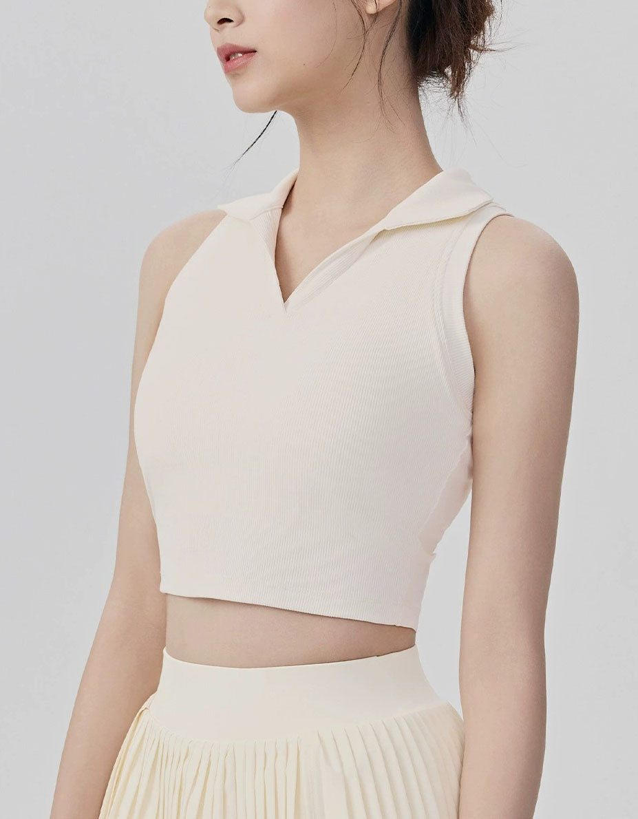 Woman wearing a light-colored sleeveless top and skirt on a plain background