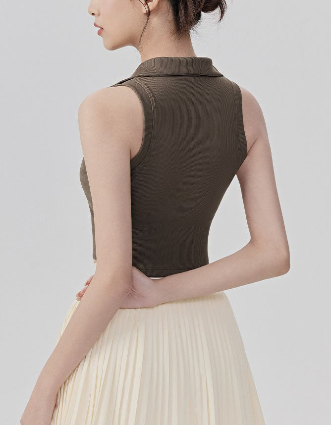 Woman wearing a brown sleeveless top and beige pleated skirt on a light gray background back view