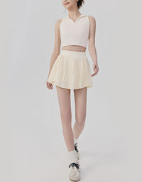Person wearing a light pink sleeveless top and pleated skirt on a white background full view