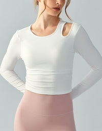 Person wearing a white long-sleeve top and pink pants on a light gray background