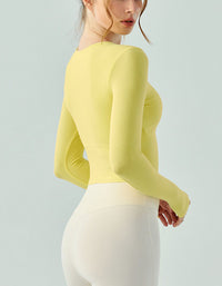 Person wearing a yellow long-sleeve top and white pants on a light gray background back view