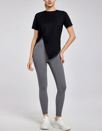 Person wearing a black t-shirt and gray leggings on a white background