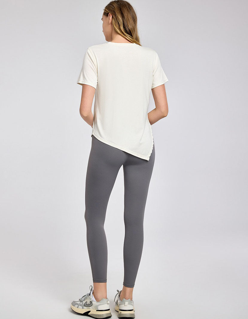 Person wearing a white t-shirt and gray leggings on a light gray background