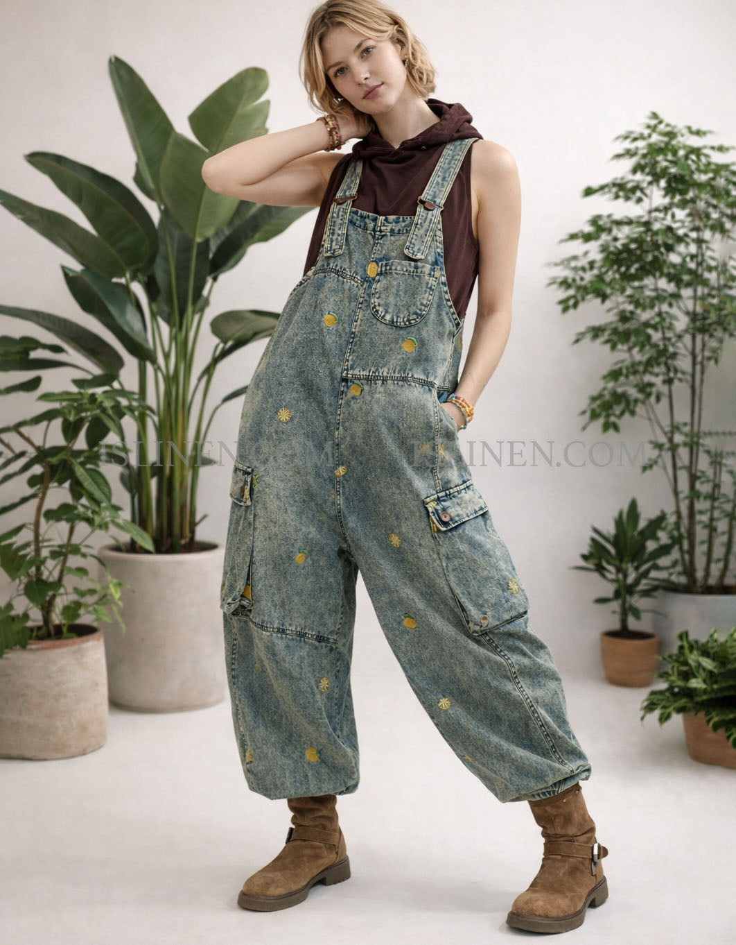 Person wearing denim overalls with plants in the background