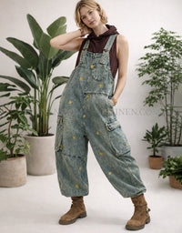 Person wearing denim overalls with plants in the background