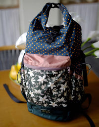 Multicolored patterned backpack on a wooden surface with a blurred background
