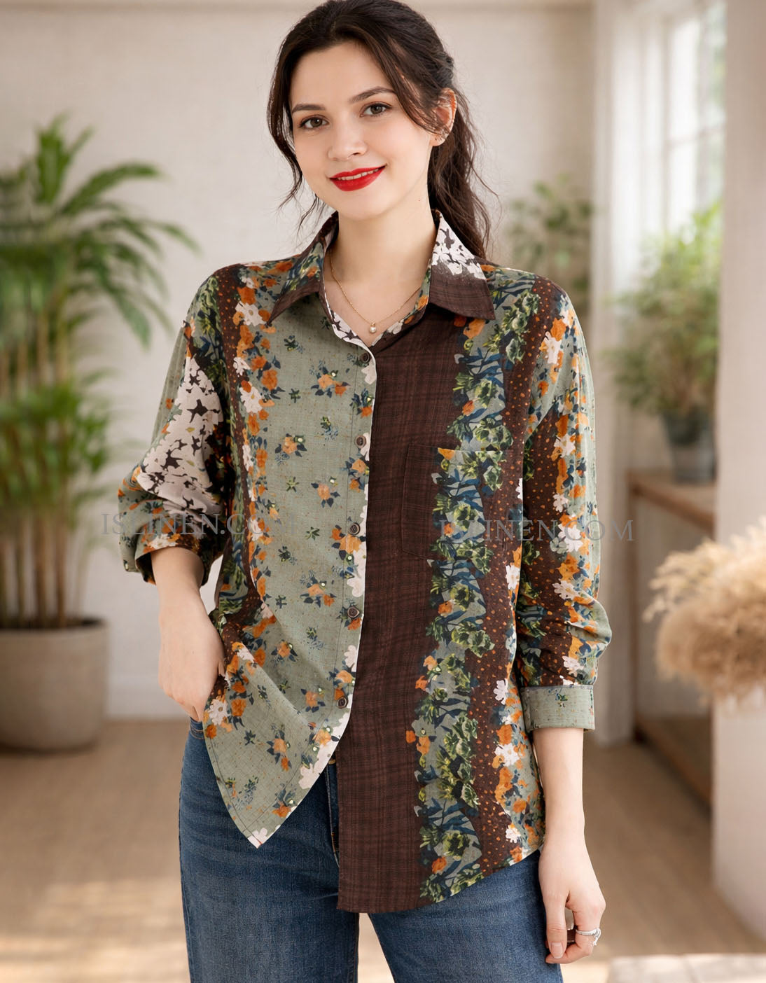 Woman wearing a floral patterned shirt over a brown top in an indoor setting with plants.