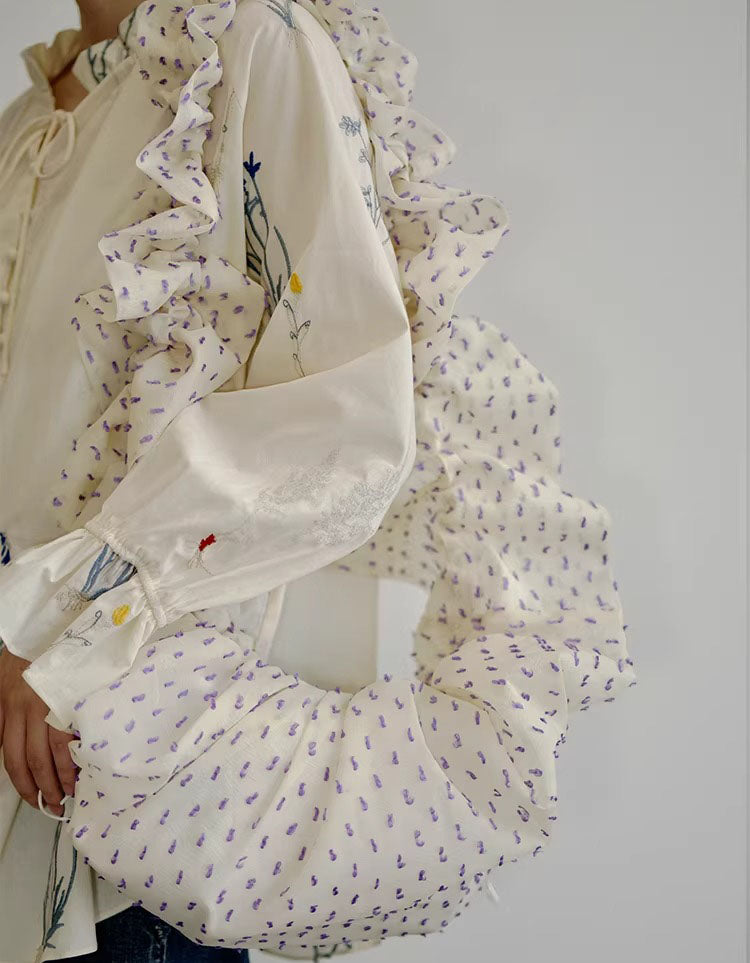 Side view of mini ruffle hobo bag showing gathered scrunchie strap and drawstring closure