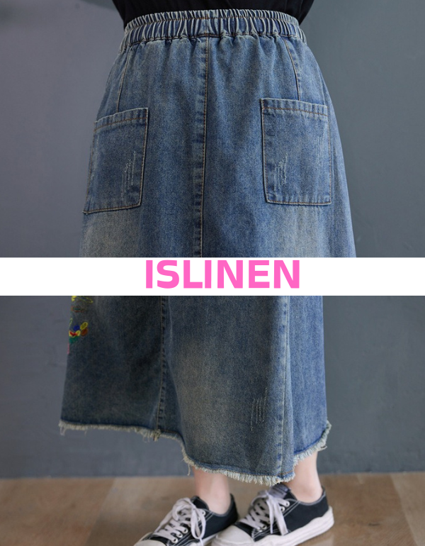 Close-up floral embroidery detail on denim midi skirt