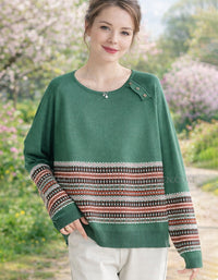 Woman wearing a green sweater with patterned sleeves in a garden setting