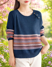 Person wearing a navy sweater with colorful patterned sleeves in a garden setting