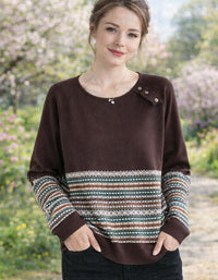 Woman wearing a brown sweater with patterned sleeves in a garden setting