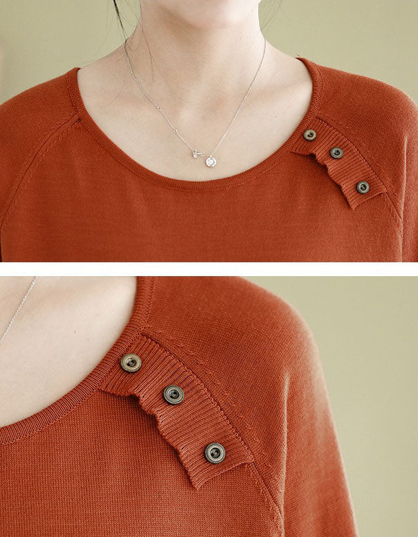 Close-up of a orange sweater with button details on a beige background