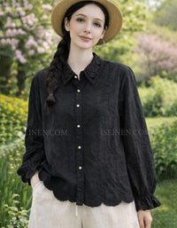 Woman wearing a black lace shirt and straw hat in a garden setting
