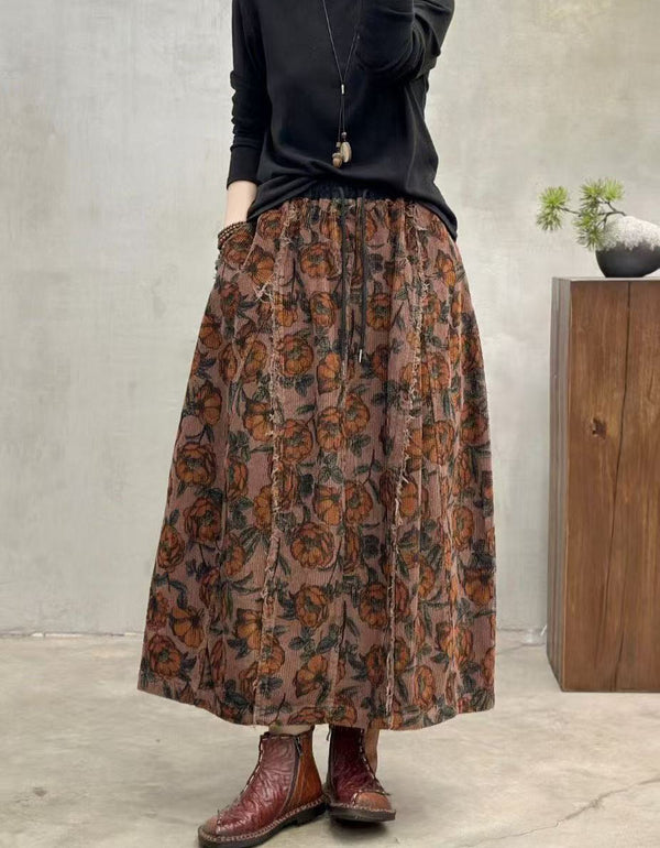 Person wearing a long floral skirt with a plain background