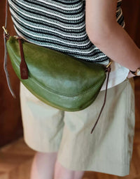 Vintage olive green leather crescent crossbody bag with adjustable strap and minimalist retro design for women