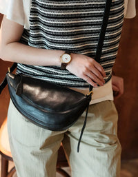 Retro inspired crescent leather bag in black with smooth texture and adjustable brown strap