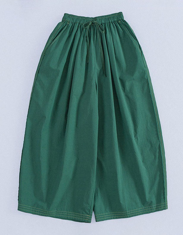 Green wide-leg pants on a light gray background