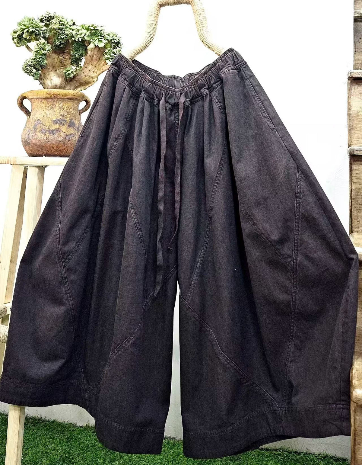 Dark washed denim culotte pants paired with casual shoes in a relaxed streetwear outfit