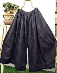 Dark washed denim culotte pants paired with casual shoes in a relaxed streetwear outfit
