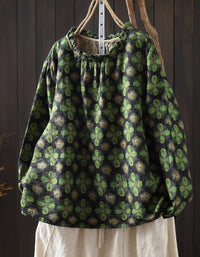 Green printed linen blouse hanging on rack