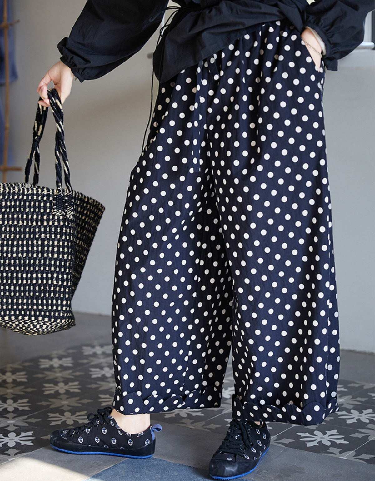 Side view of loose fit polka dot linen trousers for women