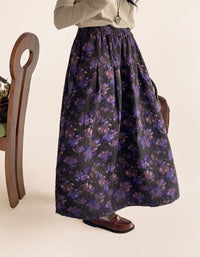 Woman wearing purple floral midi skirt with gray top and brown felt boots