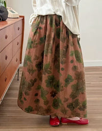 Woman wearing orange floral midi skirt with gray top and brown felt boots