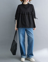 Women wearing black oversized ruffle blouse