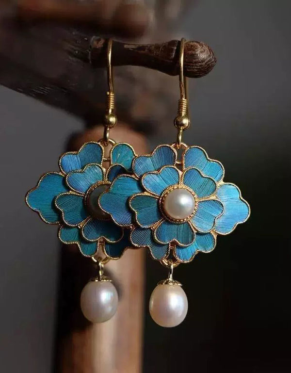 Pair of turquoise flower earrings with gold outlines and round pearl drops hanging from hooks