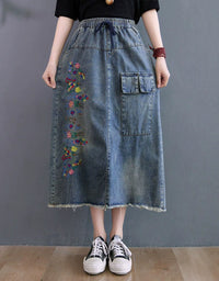 Front view of vintage embroidered denim midi skirt with elastic waist and relaxed fit