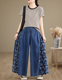Front view of women’s wide-leg denim pants featuring floral contrast panels and elastic waistband