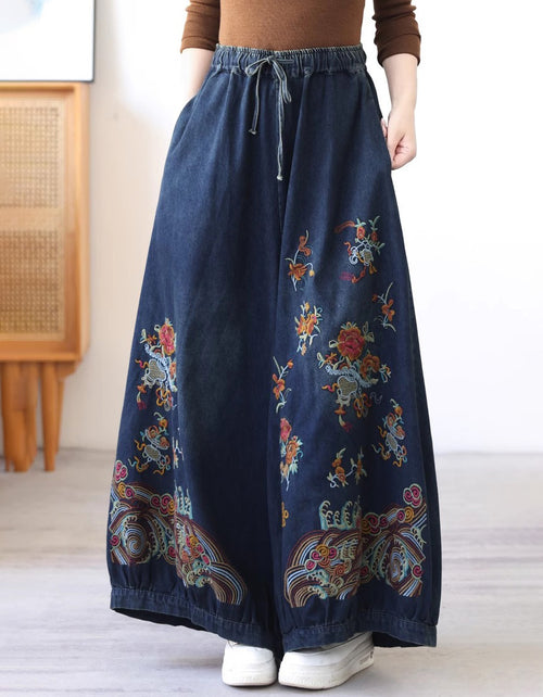 Navy blue skirt with colorful floral embroidery worn by a person indoors.