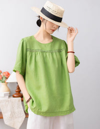 Person wearing a green top and straw hat on a plain background